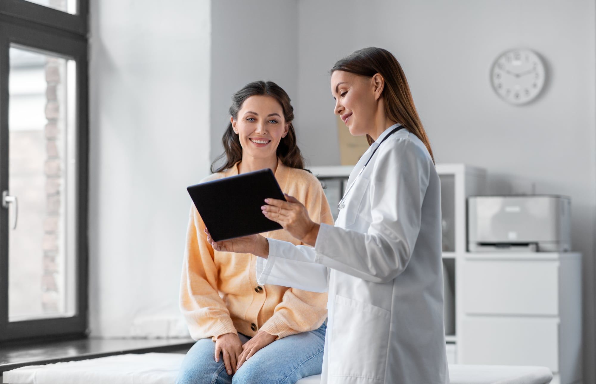 Ärztin bespricht mit einer Patientin Informationen auf einem Tablet
