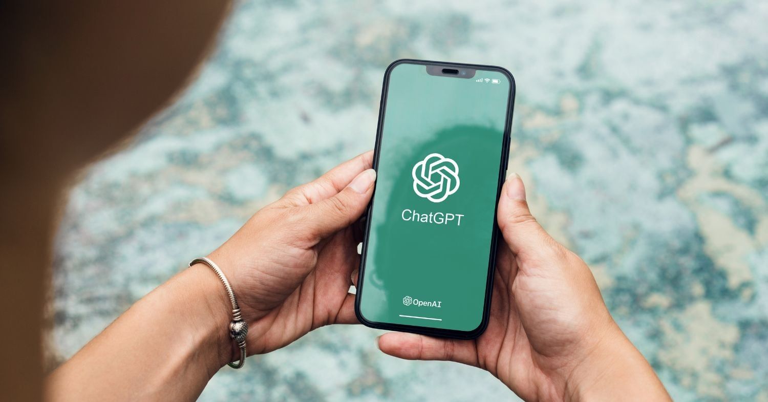 Hände halten ein Smartphone mit geöffneter ChatGPT-App