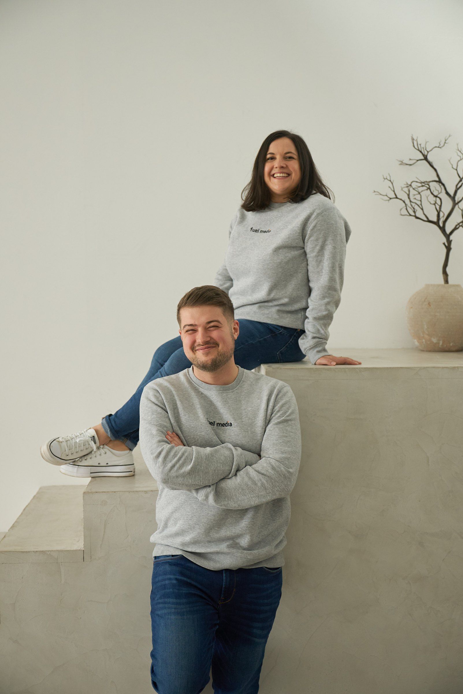 Nadja und Anton Horst, Ihre Ansprechpartner bei fuel media, auf einer hellen Treppe